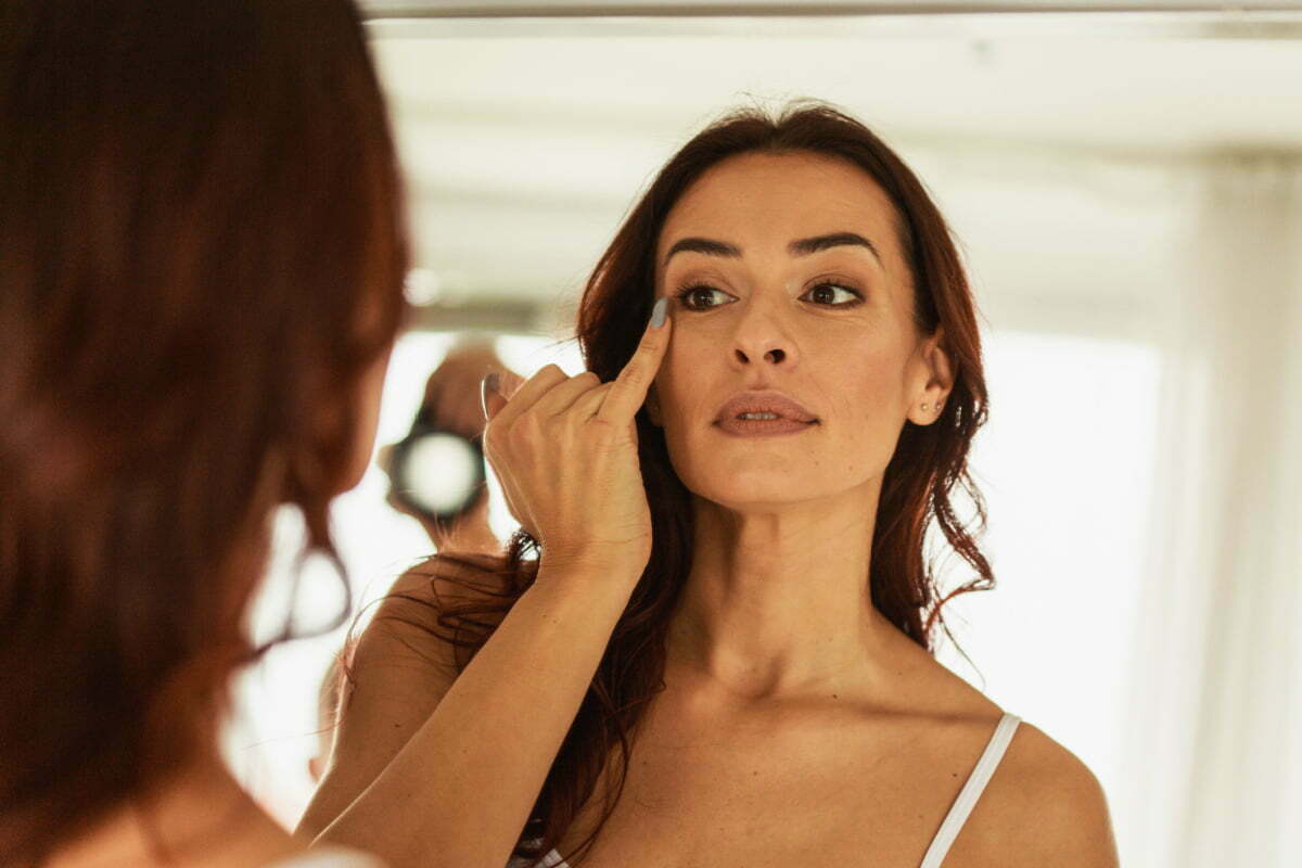 Mature Woman Examines Crows Feet Wrinkles in Mirrors for Signs of Aging