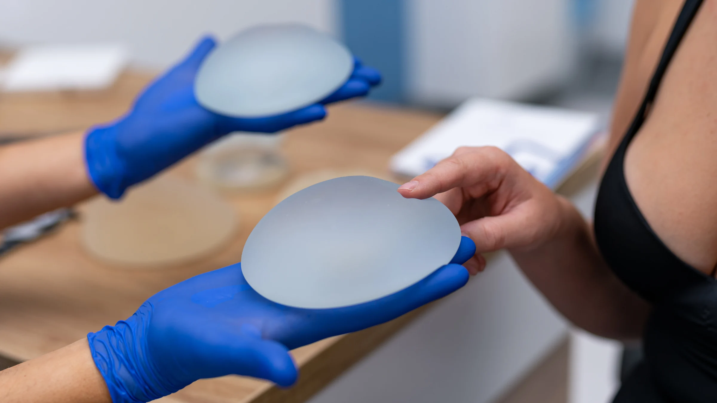 patient feeling breast implant at consultation