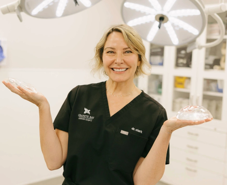 Dr. Clark holding breast implants