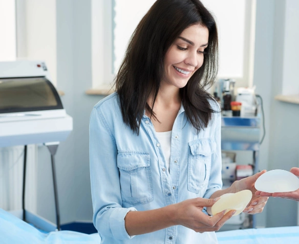 happy woman looking at different breast implant options at consultation