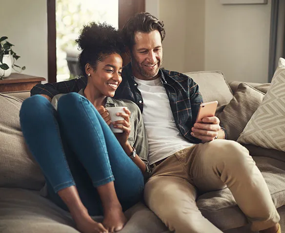 couple relaxing on couch looking at phone