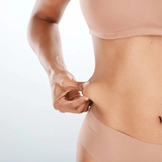 woman pinching extra skin on lower abdomen
