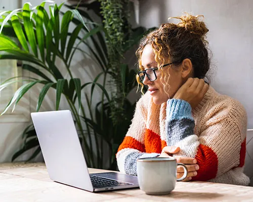 woman looking and reading on laptop