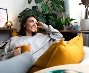 woman relaxing at home on couch with cup of coffee