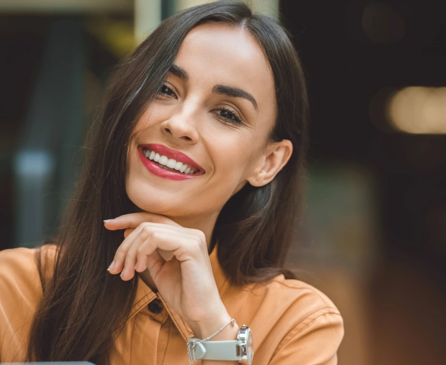 woman smiling with hair tucked behind ear