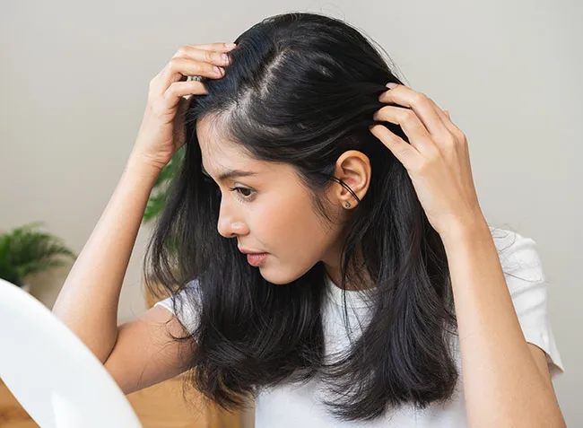 Woman checking scalp worrying about hair loss