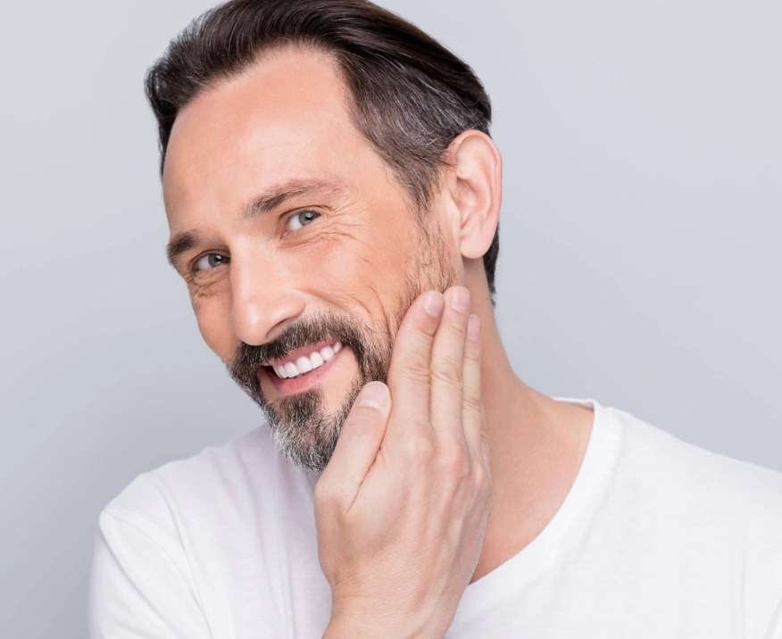 middle-aged man touching face with clear skin