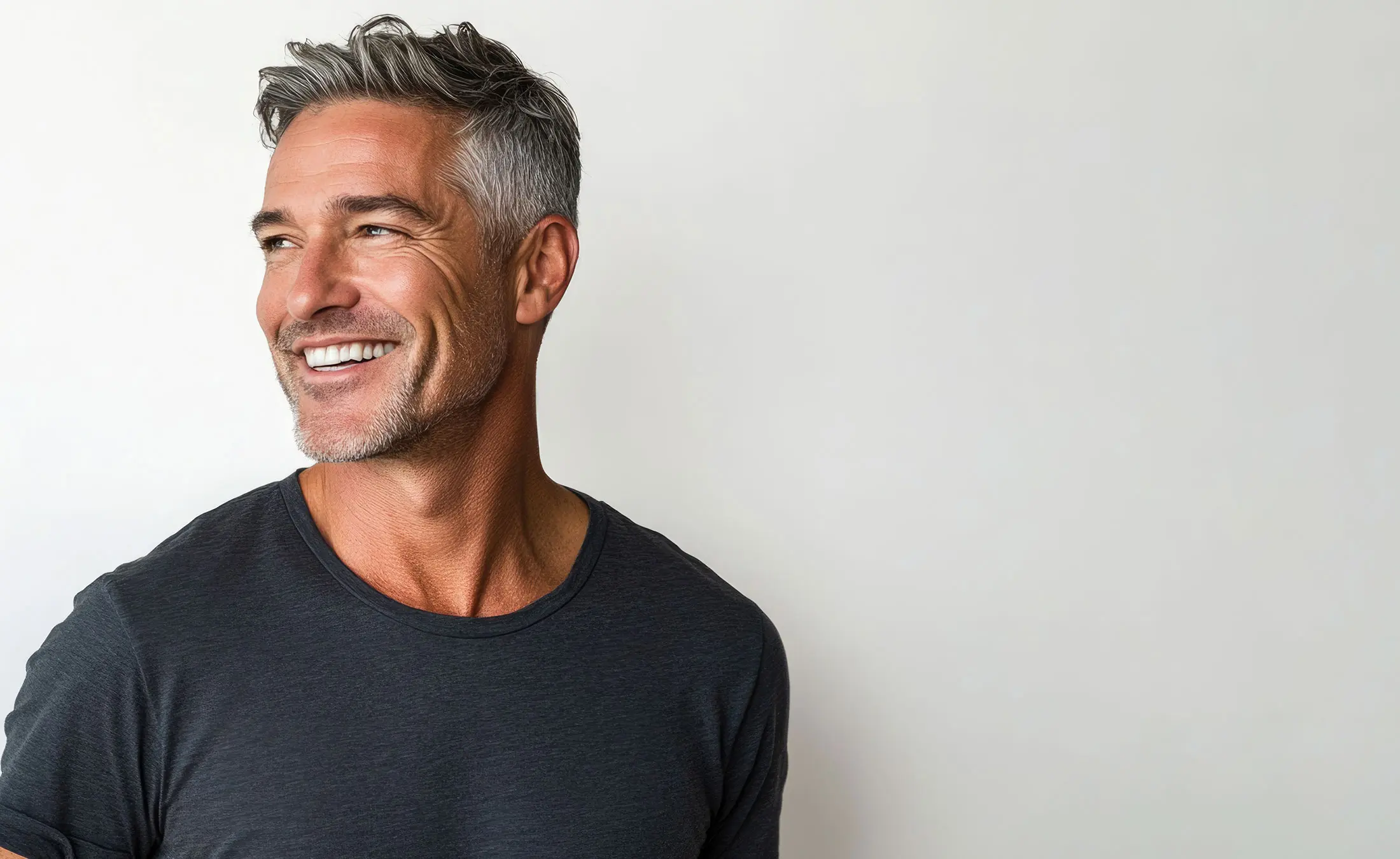 Confident middle aged man smiling in casual attire.