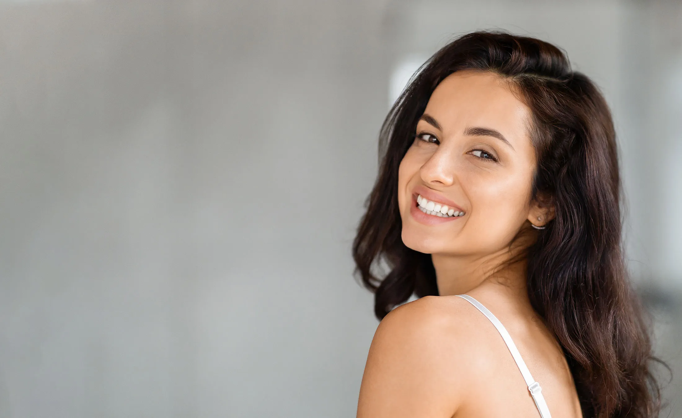 Portrait of attractive brunette long-haired woman smiling at camera