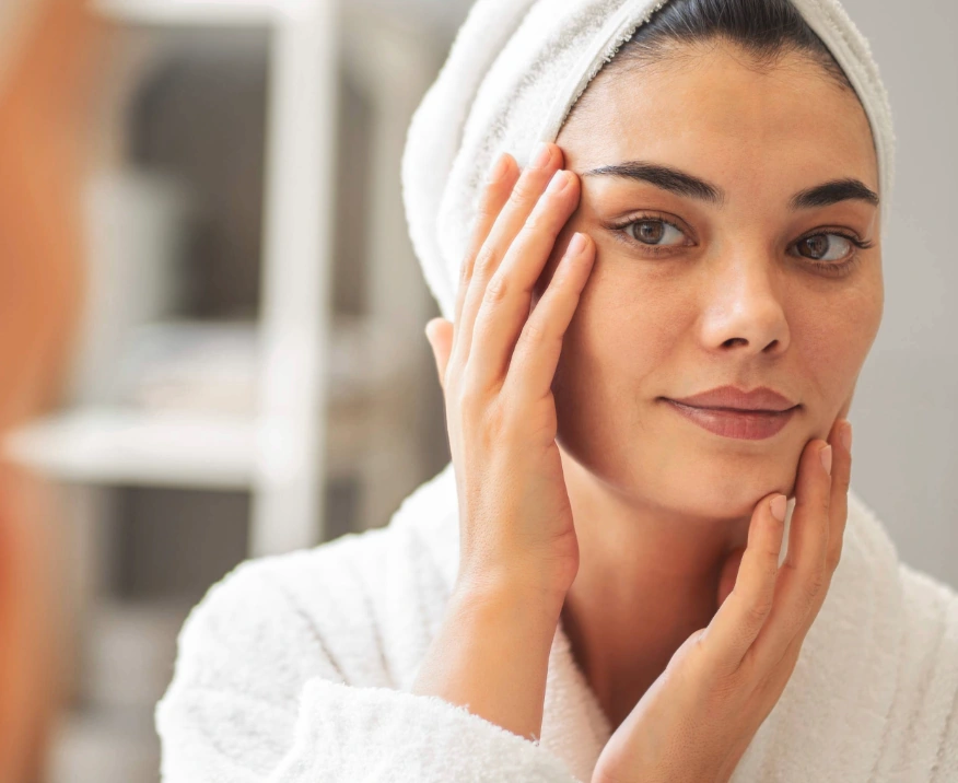 woman with clear skin looking in mirror at IPL results