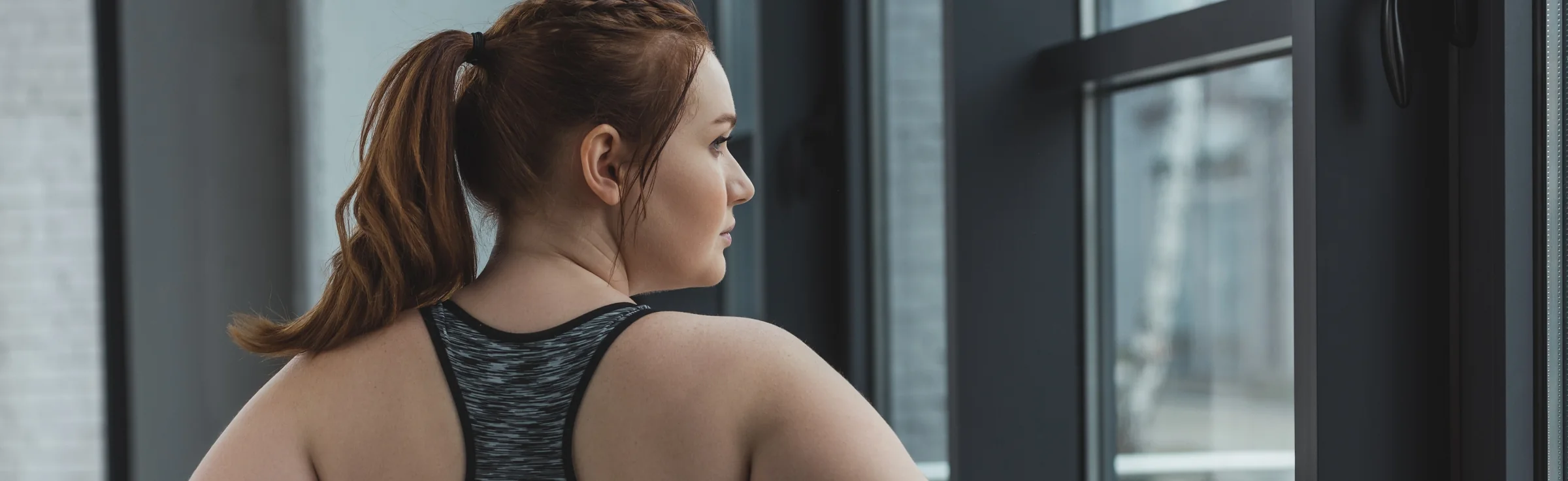 Plus size woman wearing sports top in gym