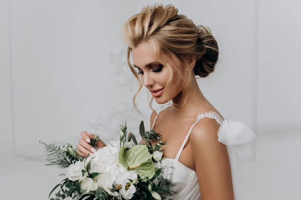 beautiful bride holding flowers while looking at them